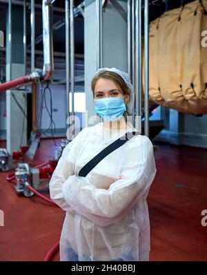 Processing Female Employee A woman employee in a beverage factory scrutinizes bottles on a ...