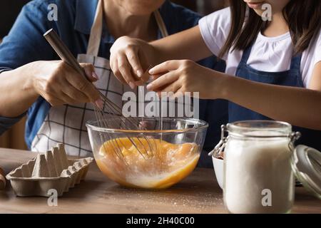 Grandkid helping grandma to cook omelet for breakfast Stock Photo