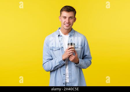 Lifestyle, people emotions and leisure concept. Handsome young man with white smile, order takeaway coffee in cafe, drinking fro Stock Photo