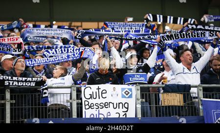 Hamburg, Germany. 30th Oct, 2021. Football: 2. Bundesliga, Matchday 12, Hamburger SV - Holstein Kiel at Volksparkstadion. Fans of Hamburger SV celebrate their team and show a poster for the injured Tim Leibold with the text 'Gute Besserung Leibe 21'. Credit: Christian Charisius/dpa - IMPORTANT NOTE: In accordance with the regulations of the DFL Deutsche Fußball Liga and/or the DFB Deutscher Fußball-Bund, it is prohibited to use or have used photographs taken in the stadium and/or of the match in the form of sequence pictures and/or video-like photo series./dpa/Alamy Live News Stock Photo