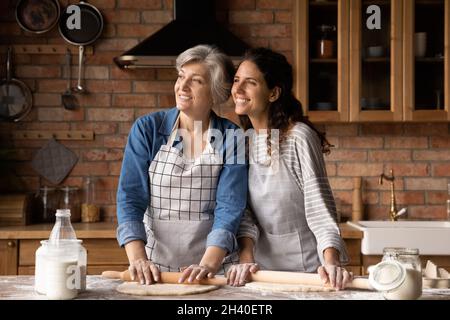 Happy mature 60s mother and grown daughter woman baking pie Stock Photo