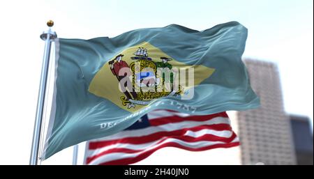 the flag of the US state of Delaware waving in the wind with the American stars and stripes flag blurred in the background. On December 7, 1787, Delaw Stock Photo