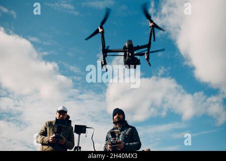Man pilot controlling quadcopter drone with remote controller pad Stock Photo