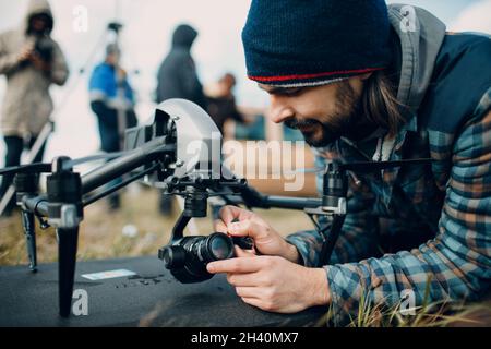 Man pilot checking quadcopter drone before aerial flight and filming. Stock Photo