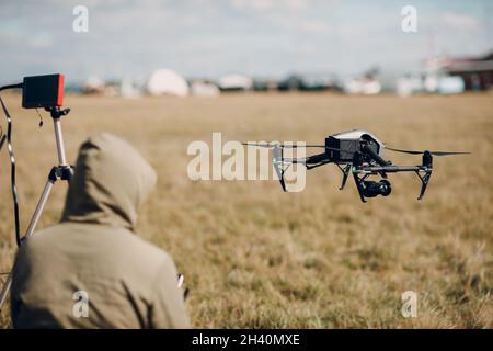 Man pilot controlling quadcopter drone with remote controller pad Stock Photo