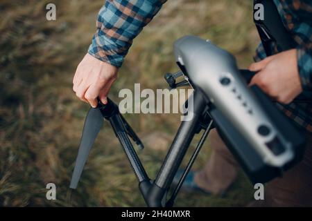 Man pilot checking quadcopter drone before aerial flight and filming. Stock Photo