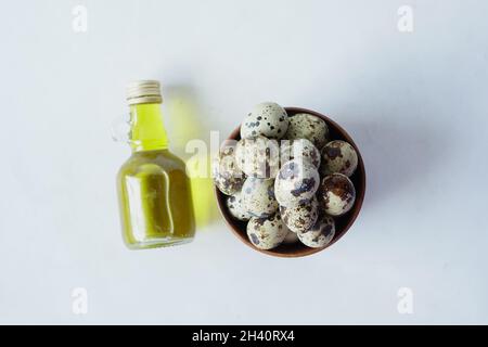 top view of Quails eggs in a bowl with oil on white background  Stock Photo