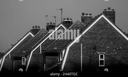 A side view of a row of Dutch style gambrel roof gable ends in black and white in Lincolnshire. Stock Photo