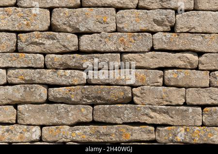 Sideways on shot of a random bond drystone wall made from flat grey blocks with lichen growth Stock Photo