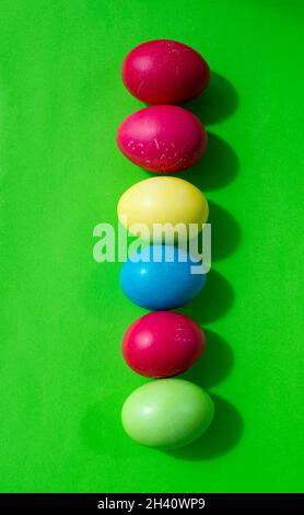Easter backgrounds. Multicolored Easter eggs on a bright green background. Vertical. Stock Photo