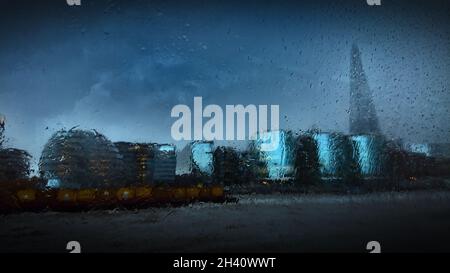 Abstract gloomy view of London City Hall, The Shard and other surrounding offices through a rain soaked window of a Thames river cruiser Stock Photo