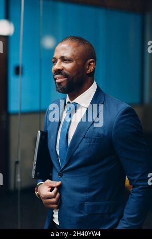 Portrait smiling african american businessman in blue suit in office Stock Photo