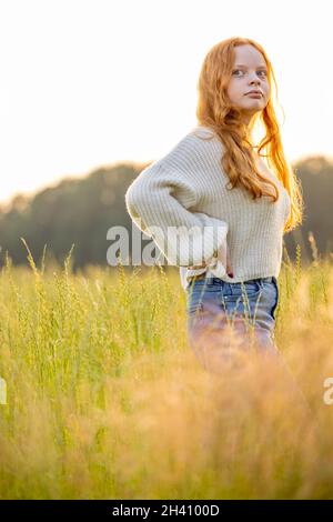 Fall fashion concept. Beautiful young woman in a cozy knitted sweater. Outdoor photo of funny hipster girl wearing trendy casual