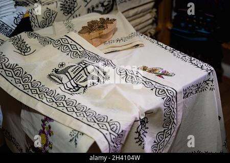 TOKAT, TURKEY - AUGUST 6, 2021: Shop shelves with Tokat style hand printed textile cotton fabrics next to a wooden pattern mold crafted in a centuries Stock Photo