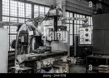 Old milling machine with control panel equipment and tools for metal processing in the workshop of an industrial plant. Stock Photo