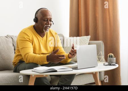 Senior Black Man Video Calling Talking To Laptop At Home Stock Photo