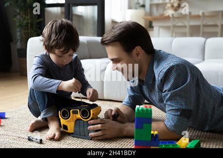 Concentrated small boy fixing car with caring dad. Stock Photo