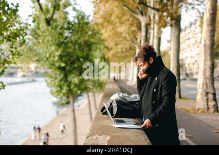 Hispanic professor in detached duty working with laptop. Stock Photo
