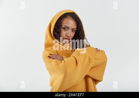 Young african woman in brown hoodie on white background Stock Photo