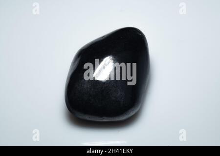 natural black shungite cabochon on background Stock Photo