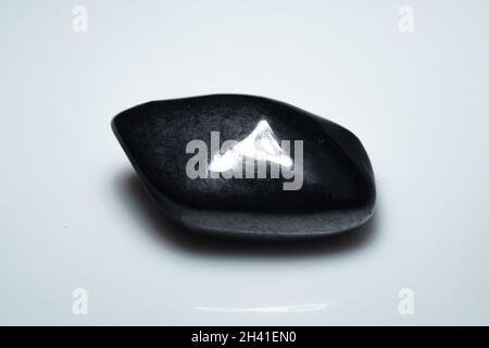 natural black shungite cabochon on background Stock Photo
