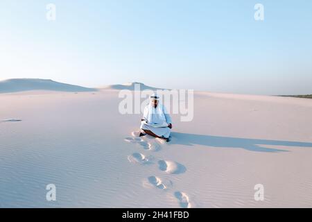 Serious young Arab businessman considering construction plan, standing among wide desert on hot summer day. Stock Photo