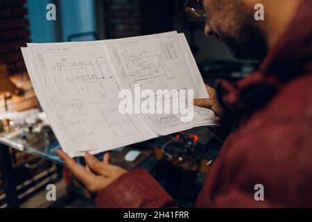 Adult young engineer working on project and hold blueprint Stock Photo