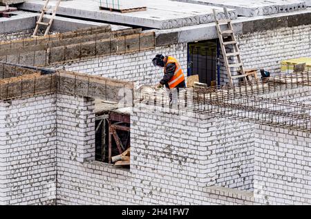 Welder worker welding building metal iron reinforcement elements at the construction site Stock Photo