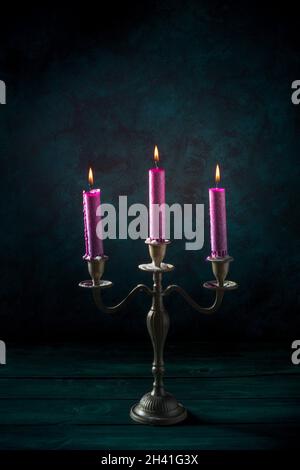 Candle magic. Purple candles in a vintage candleholder Stock Photo