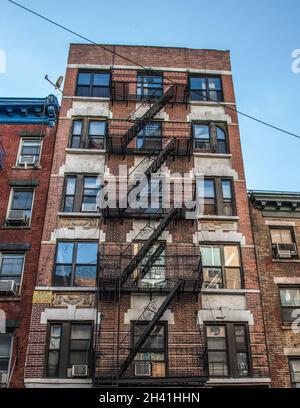 Traditional fire escape ladders at the facade of a New York's apartment, USA Stock Photo