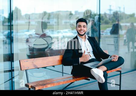 Cool guy arabic man uses laptop business center Stock Photo
