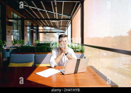 Caucasian realtor working with laptop and chatting with client on smartphone. Stock Photo