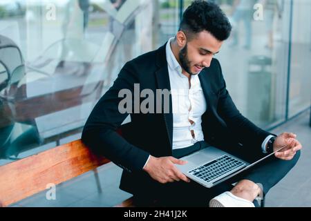Cool guy arabic man uses laptop business center Stock Photo