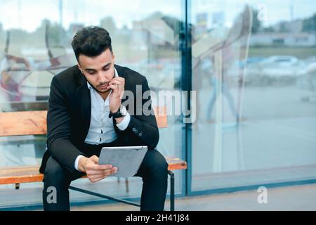 Man in suit arabic puts on sunglasses with tablet near business center Stock Photo