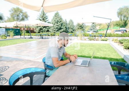 Close up hands typing on laptop keypad outside. Stock Photo