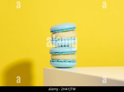 Baked blue round macarons on a yellow background, delicious dessert