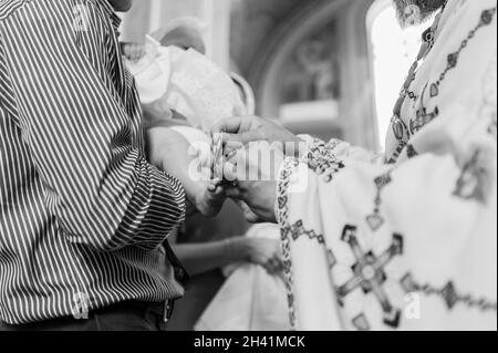 sacrament of baptism the priest baptizes the child with anointing Stock Photo