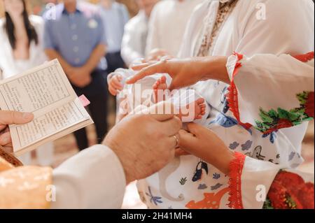 sacrament of baptism the priest baptizes the child with anointing Stock Photo