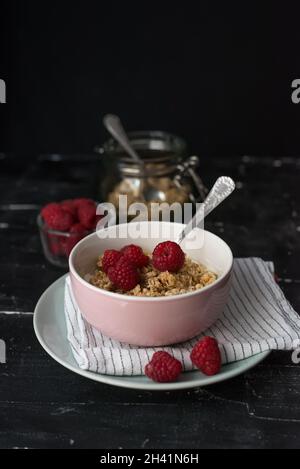 Healthy breakfast of muesli, berries with yogurt and seeds on dark background - Healthy food, Diet, Detox, Vegetarian concept. Stock Photo