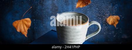 Autumn panorama with a cup of tea and autumn leaves Stock Photo
