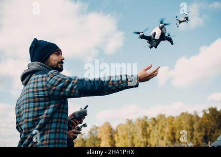 Man pilot controlling quadcopter drone with remote controller pad Stock Photo