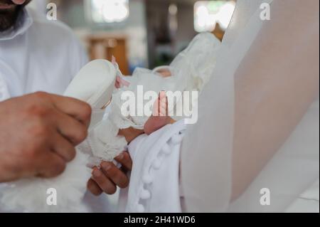 sacrament of baptism the priest baptizes the child with anointing Stock Photo