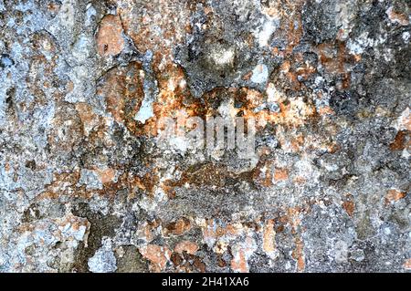 Concrete grey wall with old cracked paint. Black, grey, white and beige colors. Abstract photo background. Urban style texture. Building exterior Stock Photo