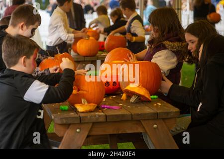 Ascot, Berkshire, UK. 30th October, 2021. Pumpkin carving time for Halloween. It was a busy day at Ascot Racecourse today for the first of the jumps season. Families also enjoyed the funfair and Halloween activities for the children. Credit: Maureen McLean/Alamy Stock Photo