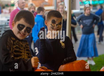 Ascot, Berkshire, UK. 30th October, 2021. Pumpkin carving time for Halloween. It was a busy day at Ascot Racecourse today for the first of the jumps season. Families also enjoyed the funfair and Halloween activities for the children. Credit: Maureen McLean/Alamy Stock Photo