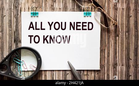 All you need to know are concepts written on a notepad. There is a magnifying glass, glasses and a pen on a wooden table. Stock Photo