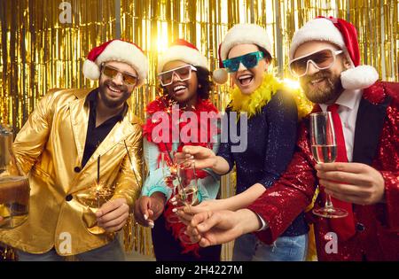 Happy friends merry christmas people group in party santa hat posing for camera Stock Photo