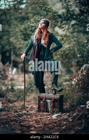 Outdoor portrait of young female in pirate with a sword. Stock Photo