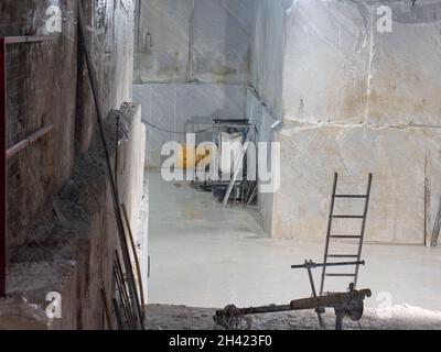 Marble Quarry with a ladder and other working tools inside the Mountain in Carrara, Tuscany - Italy. Stock Photo