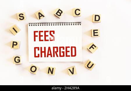 FEES CHARGED - words are written on a notepad and a white background Stock Photo